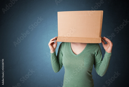 Photo: Young girl gesturing with a cardboard box on his head Young girl gesturing with a cardboard box on his head