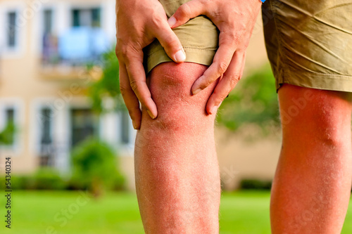 Photo: man holding hands sore knee man holding hands sore knee