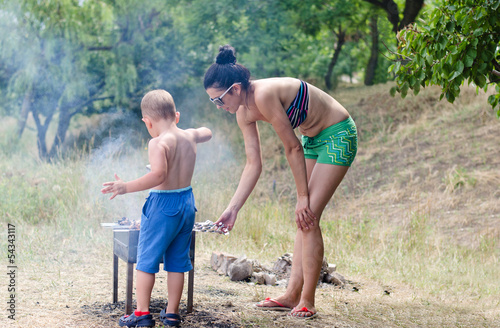 Photo: Young boy helping at the barbecue Young boy helping at the barbecue