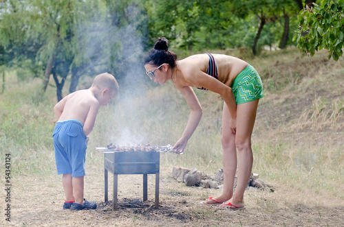 Photo: Young boy helping at the barbecue Young boy helping at the barbecue