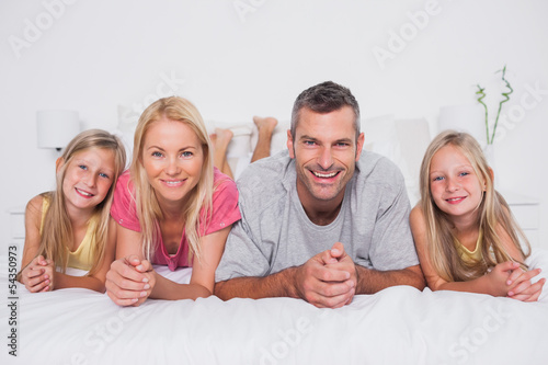 Photo: Parents lying in bed with their children Parents lying in bed with their children