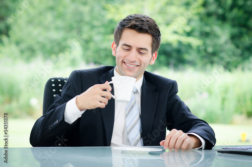 Photo: junger geschäftsmann macht eine kaffeepause junger geschäftsmann macht eine kaffeepause
