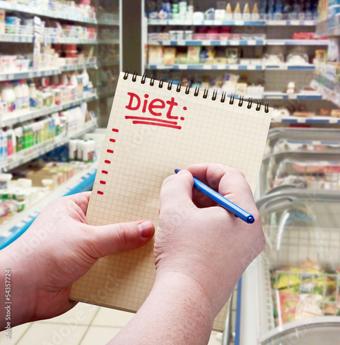 Photo: hand holds a notepad with diet plan hand holds a notepad with diet plan