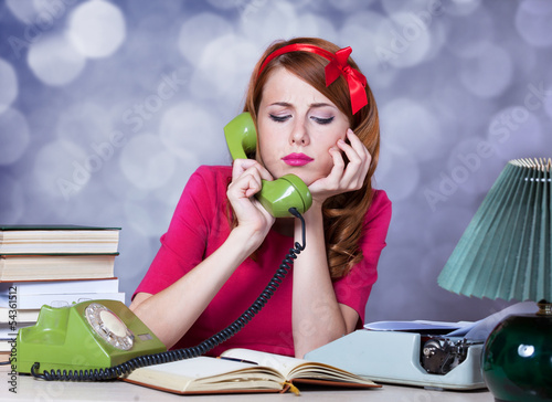 Photo: Woman at typewriter on telephone Woman at typewriter on telephone