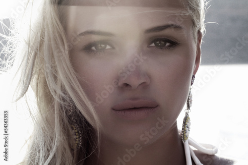 Photo: Beautiful blond woman on the beach. light on tha face.sunset Beautiful blond woman on the beach. light on tha face.sunset
