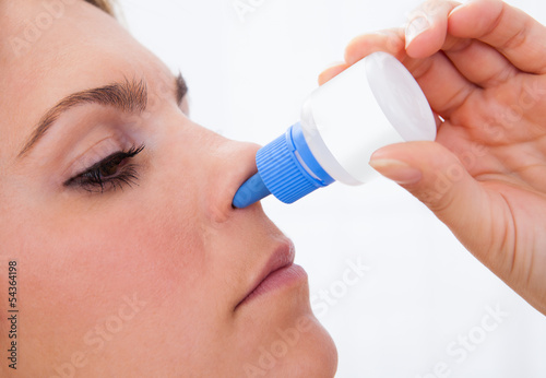 Photo: Woman using nasal spray Woman using nasal spray