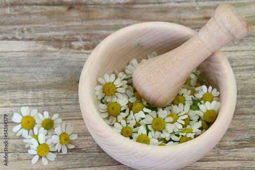 Photo: Chamomile flowers in wooden mortar with copy space Chamomile flowers in wooden mortar with copy space