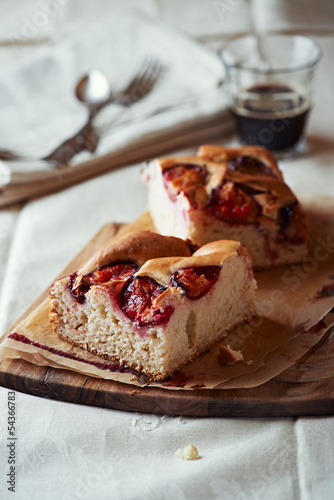 Photo: Homemade plum cake on wooden kitchen board Homemade plum cake on wooden kitchen board