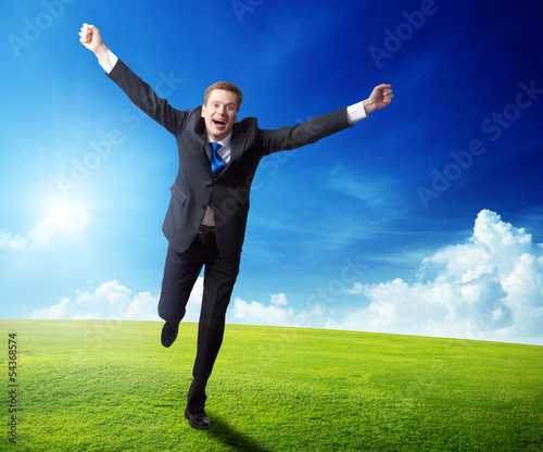 Photo: happy business man running on spring field happy business man running on spring field