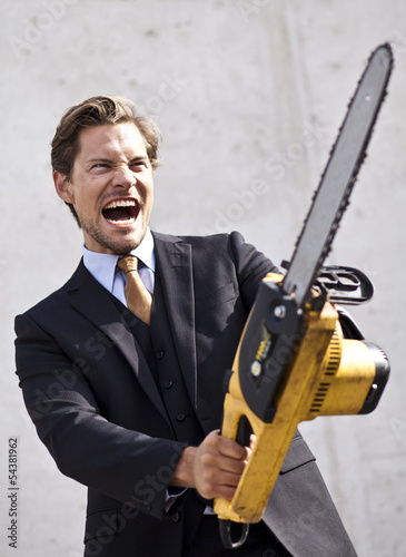 Photo: Angry businessman with blurred chainsaw Angry businessman with blurred chainsaw