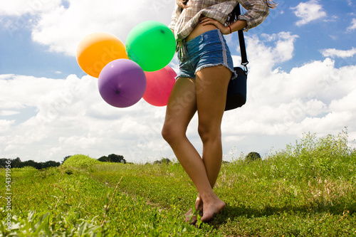 Photo: Girl with colored balloons in the field Girl with colored balloons in the field