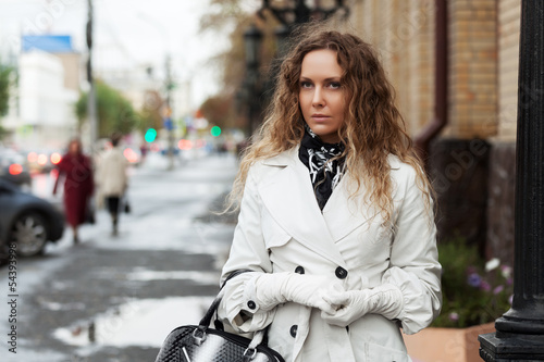 Photo: Beautiful woman in white on the city street Beautiful woman in white on the city street