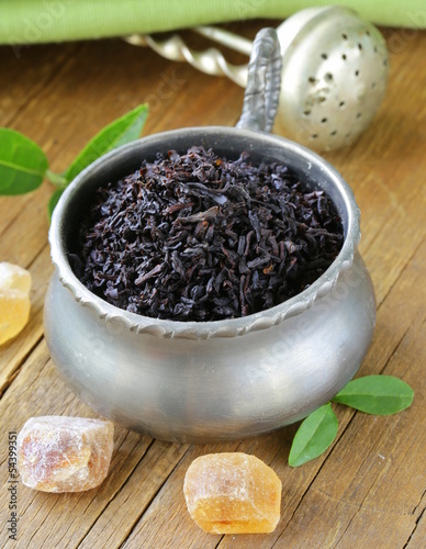 Photo: granulated black tea in a metal cup on a wooden table granulated black tea in a metal cup on a wooden table