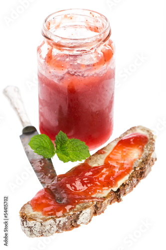 Photo: Erdbeermarmelade im Glas mit Brot, Messer und Minze Erdbeermarmelade im Glas mit Brot, Messer und Minze