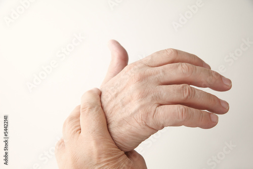 Photo: senior man holds his aching hand senior man holds his aching hand