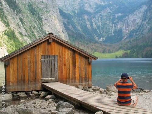 Photo: mann sitzt am holzsteg mann sitzt am holzsteg