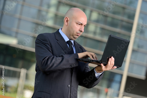 Photo: Manager con computer portatile in esterni Manager con computer portatile in esterni