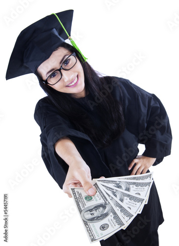 Photo: Beautiful graduate holding money - isolated Beautiful graduate holding money - isolated