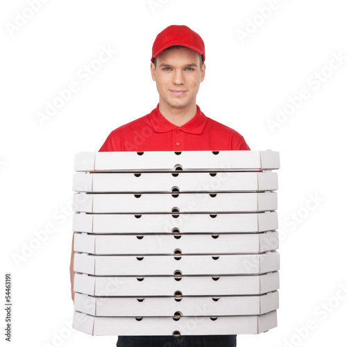 Photo: Your pizza! Young cheerful pizza man holding a stack of pizza bo Your pizza! Young cheerful pizza man holding a stack of pizza bo