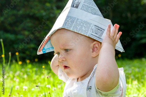 Photo: Baby with Paper on the summer meadow Baby with Paper on the summer meadow