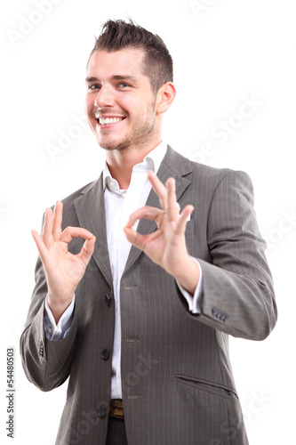 Photo: Happy smiling young business man with thumbs up gesture Happy smiling young business man with thumbs up gesture