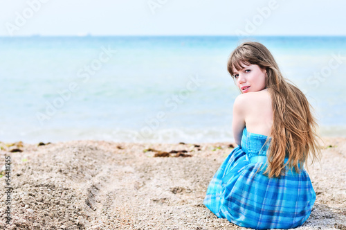 Photo: woman sitting alone at the beach woman sitting alone at the beach