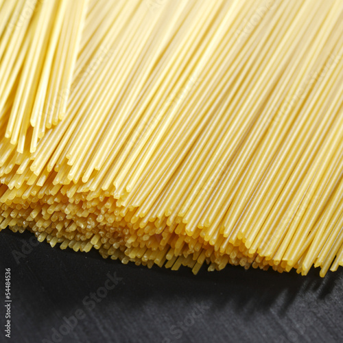 Photo: Raw pasta on black table Raw pasta on black table