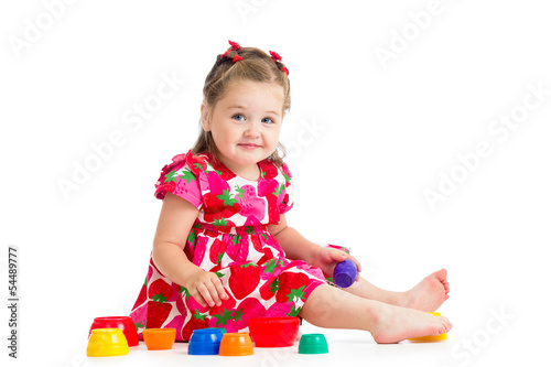 Photo: baby girl playing with cup toys, isolated over white baby girl playing with cup toys, isolated over white