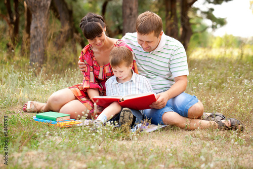 Photo: Happy family reading together. Happy family reading together.