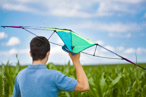 Photo: Teen with kite on a corn field in summer Teen with kite on a corn field in summer