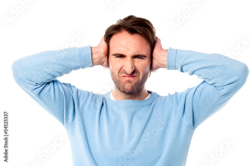Photo: Irritated man blocking his ears Irritated man blocking his ears