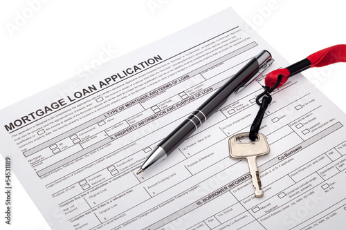 Photo: House key with mortgage loan application House key with mortgage loan application