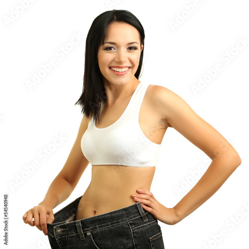 Photo: Beautiful young woman with big jeans isolated on white Beautiful young woman with big jeans isolated on white