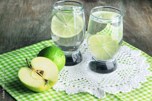 Photo: Glasses of cocktail with lime on napkin on dark wooden table Glasses of cocktail with lime on napkin on dark wooden table