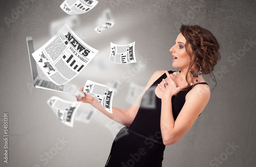 Photo: Casual young woman holdin notebook and reading the explosive new Casual young woman holdin notebook and reading the explosive new
