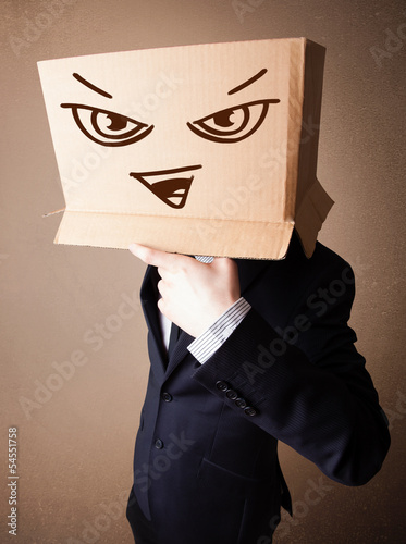 Photo: Businessman gesturing with a cardboard box on his head with evil Businessman gesturing with a cardboard box on his head with evil