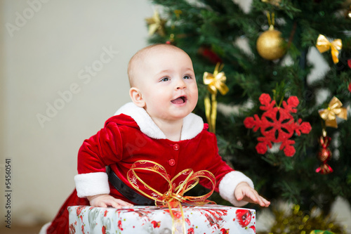 Photo: kid girl dressed as Santa Claus in front of Christmas tree with kid girl dressed as Santa Claus in front of Christmas tree with