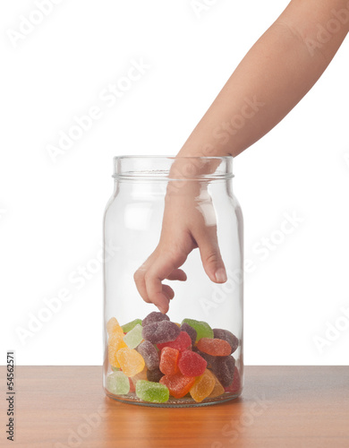 Photo: Child's hand reaching out to take candy from a jar Child's hand reaching out to take candy from a jar
