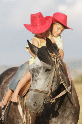 Photo: boy and girl riding a horse on farm outdoor portrait boy and girl riding a horse on farm outdoor portrait
