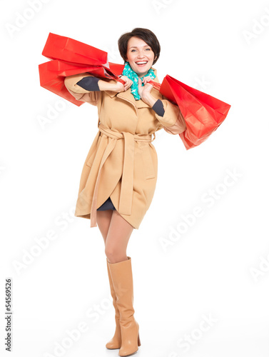 Photo: Portrait of happy woman with shopping bags in autumn coat Portrait of happy woman with shopping bags in autumn coat