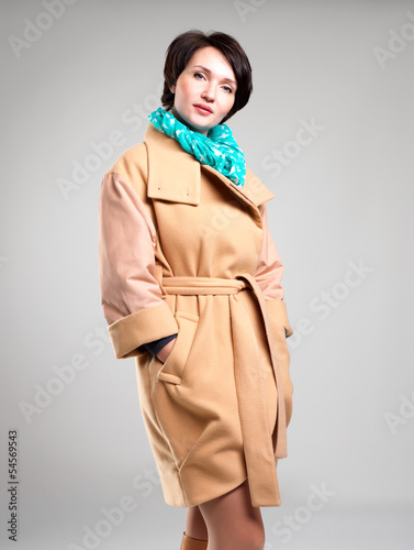 Photo: Beautiful woman in autumn coat with green scarf Beautiful woman in autumn coat with green scarf