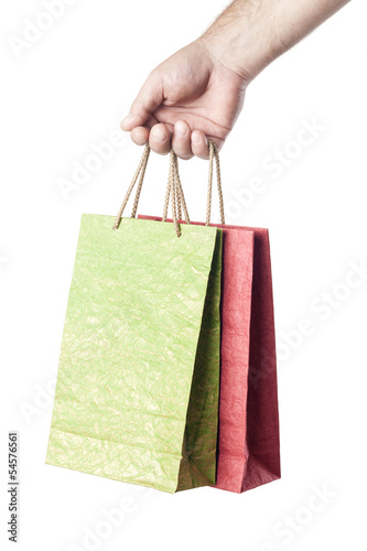 Photo: male hand holding two shopping bags isolated on white background male hand holding two shopping bags isolated on white background