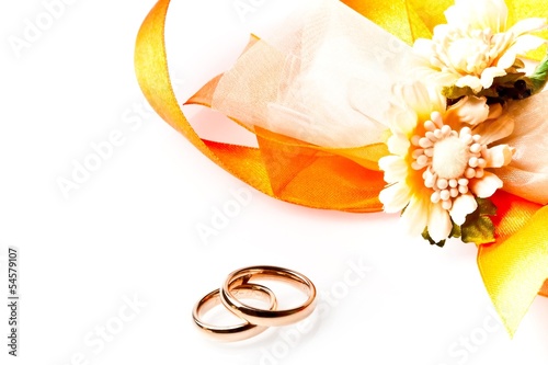 Photo: gold wedding rings near ribbon and flowers with space for text gold wedding rings near ribbon and flowers with space for text