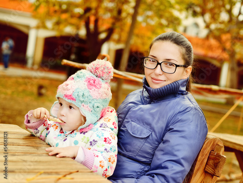 Photo: mother with baby daughter in autumn park mother with baby daughter in autumn park
