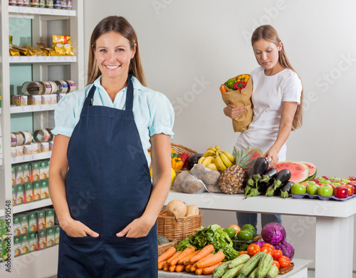 Photo: Saleswoman With Female Customer Shopping At Supermarket Saleswoman With Female Customer Shopping At Supermarket
