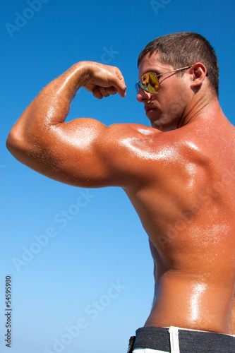 Photo: Muscular brutal man on the beach Muscular brutal man on the beach