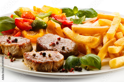 Photo: Grilled steaks, French fries and vegetables Grilled steaks, French fries and vegetables