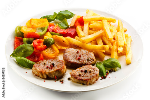 Photo: Grilled steaks, French fries and vegetables Grilled steaks, French fries and vegetables