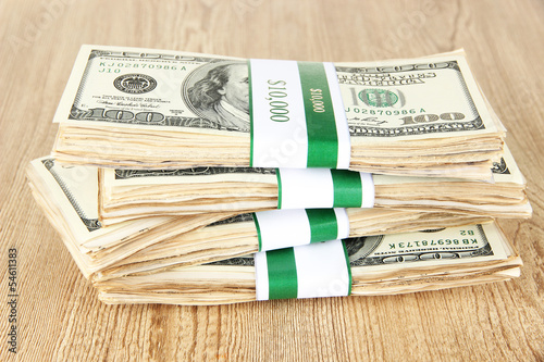 Photo: Stacks of money on wooden table Stacks of money on wooden table