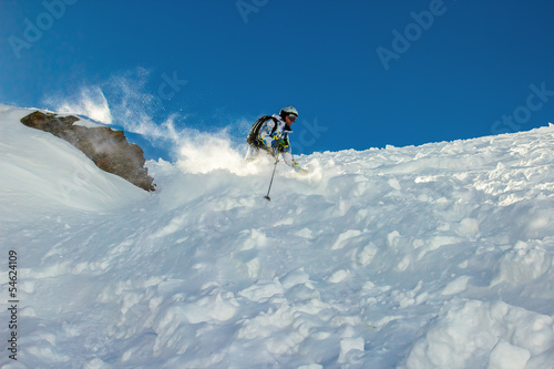 Photo: Skier in deep snow around the rock Skier in deep snow around the rock